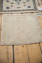 Distressed vintage Oushak rug mat corner, with subtle pattern, low pile, and machine-bound edge.