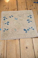 Distressed vintage Oushak rug's textured pile, with pictorial bird outline and sapphire blossoms.