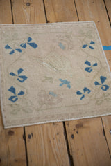 Distressed Oushak rug texture with worn sapphire blue floral motifs on a cream pile.