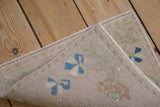 Distressed vintage Oushak rug's reverse side, machine bound edge, and worn pile.