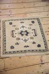Vintage distressed Oushak square rug mat with a low pile, viewed from a high overhead angle.