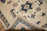 Folded corner of a vintage Oushak rug showing the blue wave border and bound edge on the back.