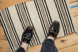 Textured vintage Turkish kilim rug with banded ivory, charcoal, beige stripes, polychromatic selvage.