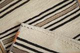 Hand woven Turkish Kilim with ivory, black, brown banded stripes and polychromatic selvage.