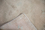 Corner view showing distressed vintage Oushak rug pile, reverse, and machine-bound edge.