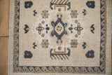 Vintage Distressed Oushak rug with cream pile, dusty navy geometric motifs, and wave border.