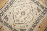 Vintage Distressed Oushak rug with softened geometric medallion in muted cream, silver, and beige.