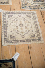 Vintage distressed Oushak square rug mat displaying geometric finned blossoms in cream and beige.