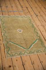 Vintage distressed ochre Oushak rug corner, emerald green stepped prayer spandrel.