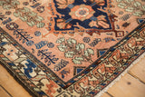 The navy medallion corner, dusty rose field, and detailed border of a fine Mehriban rug.