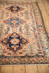 Angled view of a fine Mehriban rug's triple diamond medallions and dusty rose field.