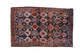 Vintage Persian Bibikabad rug with repeating artistic panels in red, blue, and fuchsia on a dark navy blue field.