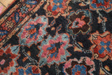 Hand-knotted pile showing raspberry, sky blue, and cobalt floral motifs on a navy field.