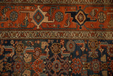 The wide Samovar-style border in terracotta above the dense navy blue Herati-patterned field.