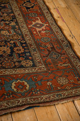 Angled view of a Kurdish Hamadan rug's terracotta Samovar border and geometric navy field.