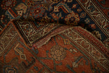 A folded corner of the antique Kurdish rug shows its low pile and hand-knotted foundation.