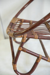 Dark rattan frame with natural woven bindings on a vintage kid's chair.
