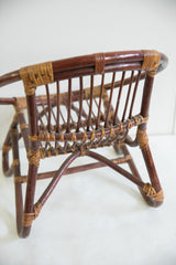 Mid Century rattan kid's chair, angled rear view with contrasting dark and light weave.