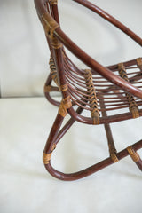 Mid century rattan chair detail, highlighting its contrasting dark brown frame and lighter woven joints.