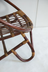 Vintage rattan chair, close-up of dark frame and natural woven bindings.