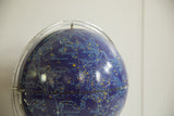 Vintage astrology globe showing blue surface, yellow stars, and light blue constellations.