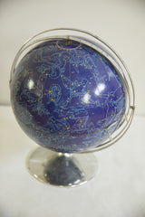 Deep blue vintage astrology globe with Hercules, Cygnus constellations, yellow stars, chrome mount.