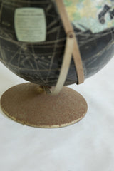 Vintage Rand McNally globe's circular base, showing textured, aged brown patina.