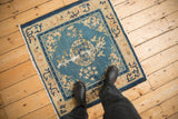 Antique Peking rug showing characterful wear across its roundel medallion and blue field.