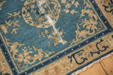 Detailed view of an antique rug's corner, highlighting wear to the knot heads and exposed foundation.