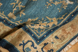 Detail of the mostly even wear and low pile texture on an antique Peking rug in shades of blue and ivory.