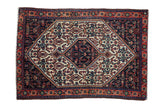 Vintage Persian Senneh rug with a stepped hexagonal medallion and Herati pattern in navy, ivory, and terracotta.