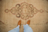 Faded scalloped medallion and floral details on a distressed beige Oushak runner.