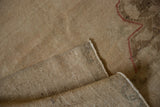 Vintage Oushak runner's distressed beige pile, faint red pattern, and reverse woven foundation.