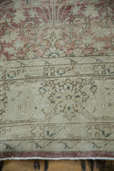 Textured close-up of vintage distressed Sparta rug, highlighting dusty raspberry thousand flower motif and faint arabesque border.