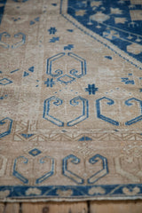 Close-up detail of the worn, hand-knotted pile on a vintage Oushak runner with blue geometric motifs.