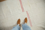 Hand-stitched seam of a multi-piece vintage hemp kilim with offset grapefruit-pink stripes.