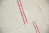 A hand-stitched seam joining panels of a vintage hemp kilim with offset pink stripes.