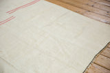 Angled view showing the hand-seamed panels and textured plain-weave of a vintage hemp kilim.