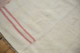 Embossed markings and hand-stitched seam on a vintage Turkish hemp kilim carpet.