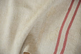 The nubby, plain-weave texture of a vintage hemp kilim with grapefruit-pink stripes.