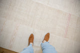 Close-up of the hemp kilim's textured weave, seam, and dusty pink horizontal stripes.