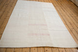 Angled view of the vintage hemp kilim's seamed panel construction and subtle horizontal stripes.
