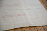 A seam joins two hand-woven hemp panels of a vintage kilim with dusty pink stripes.