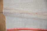 A soft fold reveals the detailed plain-weave texture of a vintage hemp kilim.
