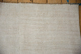 Textured plain-weave and vertical seam detail on a vintage hemp kilim with a fringed end.
