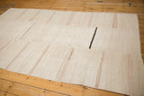 Angled view of a striped vintage hemp kilim, showing the seamed panels along its length.