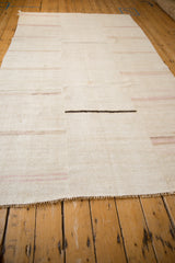 Vintage hemp kilim from a long angle showing seamed construction and soft horizontal stripes.