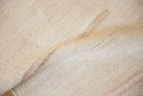 A soft fold shows the natural plain-weave texture of the hand-woven vintage hemp kilim.