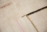 The plain-weave underside and machine-seamed construction of a vintage striped hemp kilim carpet.