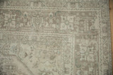 Distressed vintage Turkish Tabriz rug corner showing muted geometric floral patterns.